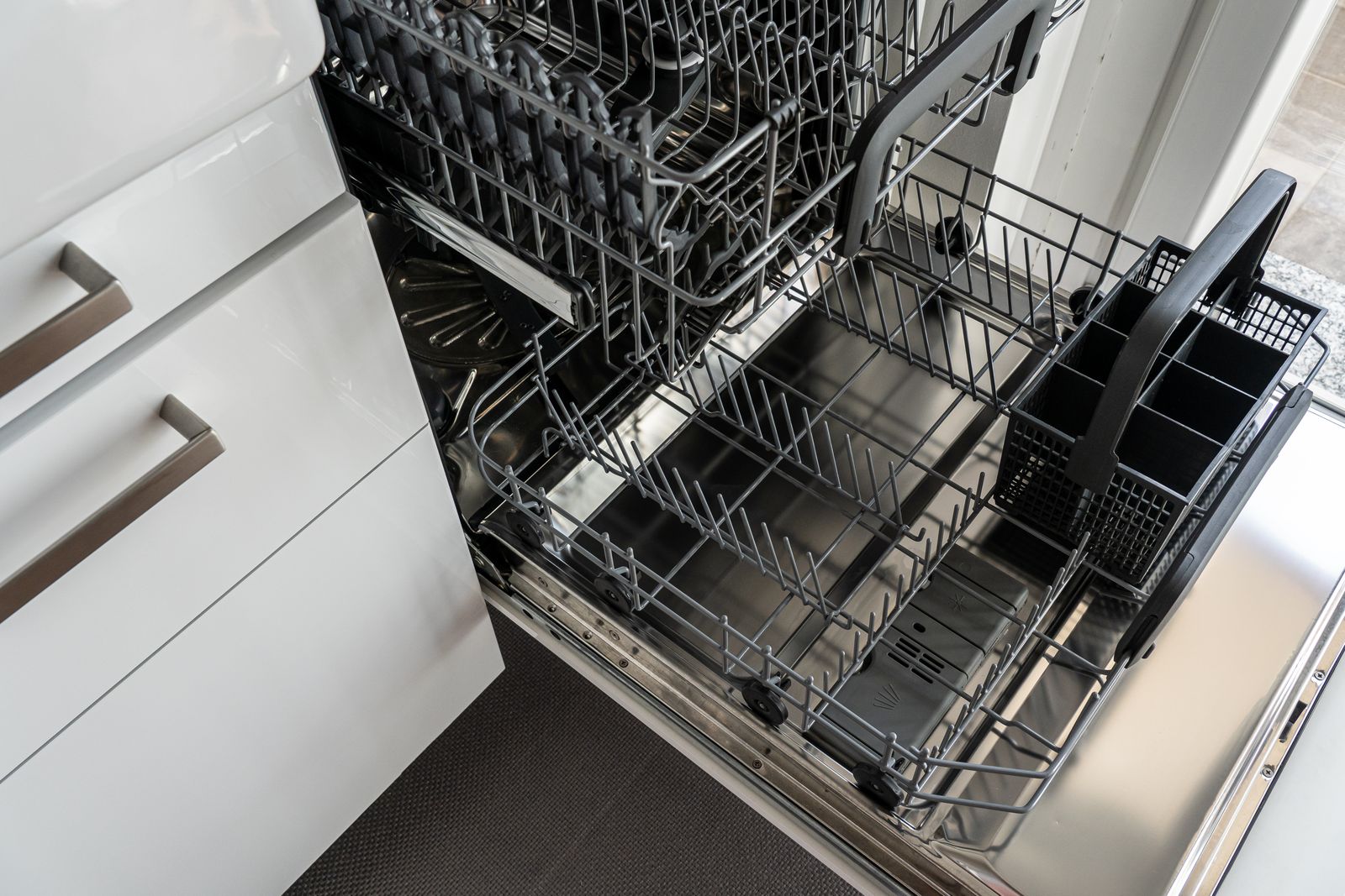 A fully integrated dishwasher open in a modern kitchen — professional Miele dishwasher repair
