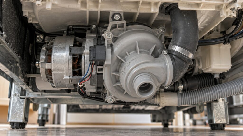 A dishwasher circulation pump with its volute housing and speed sensor connector seen from beneath the tub